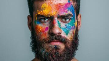 Portrait of a man with vibrant colors painted on his face, showcasing artistic expression and individuality in a studio setting. photo