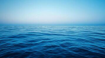 Vast ocean expanse meets a serene sky, a tranquil scene of nature's beauty. Gentle waves create mesmerizing patterns across the water. photo