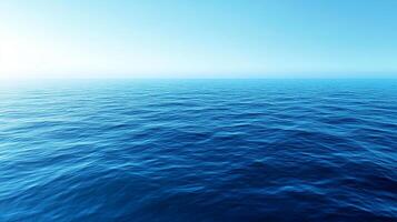 Serene seascape with a clear blue sky fading into a calm ocean, its gentle waves reflecting light, evoking peace and vastness. photo