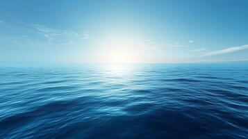 Vast ocean reflecting the sky, gentle waves creating patterns, a serene and expansive view of the open sea under a clear blue sky. photo
