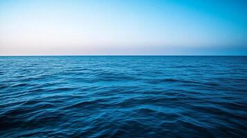 An endless expanse of blue ocean water meets a serene sky, creating a peaceful and calming seascape perfect for relaxation or inspiration. photo