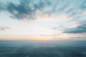 Horizon meets sky, painting the seascape with gentle light and soft clouds during sunset. A soothing, open vista. photo