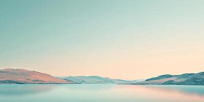 Scenic landscape featuring a serene lake reflecting the pastel colors of the sky, with distant hills adding depth and tranquility. photo