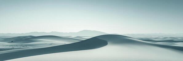 Sweeping sand dunes under a hazy sky, serene landscape with soft blue hues and distant mountains, creating a calming vista. photo