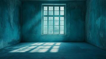 An empty, blue-toned room with sunlight streaming through a window, creating strong shadows and highlighting the textures of the weathered walls. photo