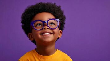 Young boy wearing glasses, looking up with a bright smile against a vibrant purple background. Innocence and optimism shine through. photo