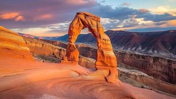 Magnificent sandstone arch standing tall against a vibrant sunset. A timeless landmark in a serene desert landscape. photo
