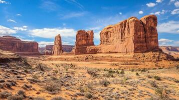 Striking desert landscape with towering sandstone formations under a bright blue sky, highlighting the majestic beauty of the arid region. photo