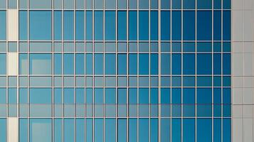 Geometric facade with blue glass windows reflecting the sky. Building exterior with clean lines and modern architectural design. photo