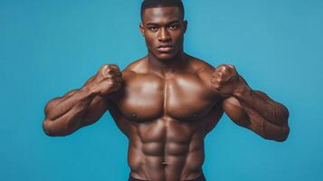 Powerful physique of a confident athlete with defined muscles showcases dedication and strength against a vibrant blue backdrop. photo