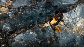 Striking patterns of dark, grey, and gold rock with a marbled effect create a dynamic texture and natural art element in a close-up shot. photo