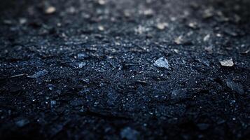 Dark, textured surface with scattered, sharp fragments. Low-angle shot emphasizes the depth and rough texture. photo