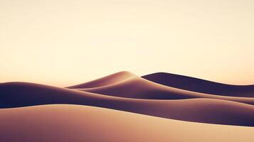A minimal landscape showing smooth sand dunes under a warm sky. The low-angle sun casts soft shadows, enhancing the curves of the dunes. photo