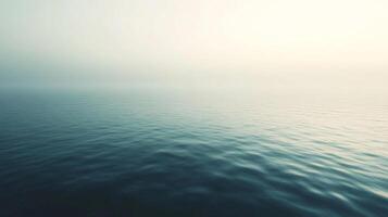 Serene seascape with gentle waves under a hazy sky, creating a tranquil and calming visual experience. Peaceful and minimalist. photo