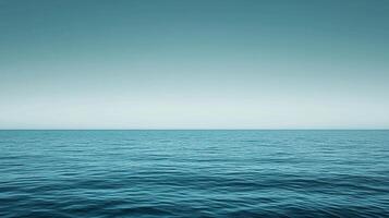 Calm turquoise sea meeting a pale, cloudless sky, creating a serene and vast ocean horizon. Evokes peace and openness in nature. photo