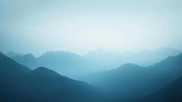 Misty blue mountains fade into the pale horizon, creating a serene and atmospheric landscape scene. Layers of peaks and valleys. photo