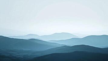 Serene mountain range in soft blue hues, creating a peaceful and vast landscape. Layers of peaks fading into the misty distance. photo