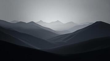 A grayscale vista of receding mountain ranges, enveloped in a soft, hazy atmosphere, evoking a sense of depth and distance. photo