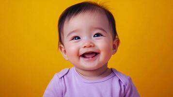 Adorable baby with a bright smile and expressive eyes on a yellow background, wearing a purple shirt. Pure joy captured in a single frame. photo