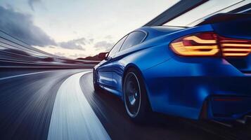 Blue car driving on the open road at speed with blurred motion, suggesting movement and speed against a vibrant, expansive backdrop. photo