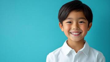 A cheerful young boy with a bright smile, radiating positivity against a vibrant turquoise background. His neat attire adds a touch of formality. photo