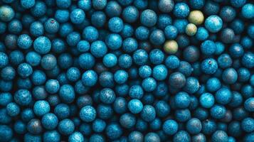 A vibrant array of small, round, blue berries filling the frame with a few off-color ones scattered for a natural texture. photo