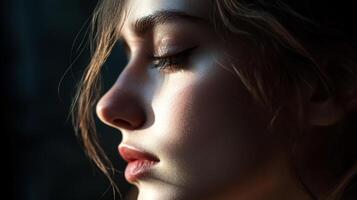 Close-up of a woman's face, illuminated by natural light. Focus on delicate features and subtle makeup. Serene and contemplative expression. photo
