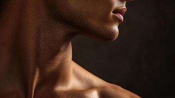 Profile of a person's neck and shoulders, emphasizing skin texture and subtle shadows against a neutral backdrop, in a close-up shot. photo