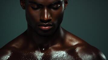 A close-up shot features a man with dark skin, eyes closed, and a serene expression. Focus on skin texture, tone and contemplative mood. photo