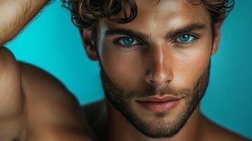 Striking portrait of a man with intense blue eyes and a chiseled face, set against a vibrant turquoise background. Modern artistry captured. photo