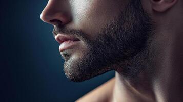 Close-up portrait featuring a man's profile with a neatly trimmed beard and shadowed face, creating a masculine and modern aesthetic. photo