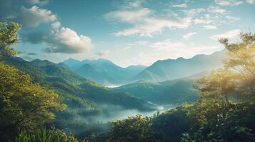 Lush green mountains cascade into a serene valley with fog, bathed in the morning light and framed by a clear, partly cloudy sky. photo