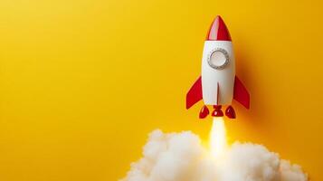 A vibrant shot featuring a red and white toy rocket taking off against a bright yellow backdrop, symbolizing ambition and new beginnings. photo