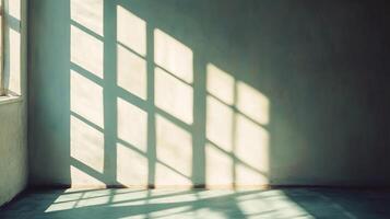 Sunlight streams through a gridded window, casting geometric patterns on the wall and floor of an empty room, creating a serene atmosphere. photo