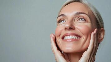 Radiant woman with a beaming smile, her hands gently touching her face, gazing upwards with an expression of joy and serene contentment. photo