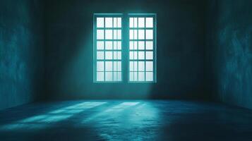 An empty dark room is lit by a window with a blue light. Rays of light reach the floor. Light gives a dramatic mood to the image. photo