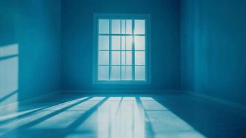 Monochromatic blue room with light streaming from a window creating linear shadows across the empty floor offering a minimalist aesthetic photo