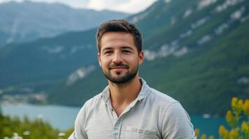 Man against a mountain backdrop, serene and peaceful, wearing a collared shirt, enjoying the natural beauty of the landscape. photo