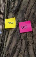 Two sticky notes on tree, one yellow with me and one pink with us, symbolize connection and individuality photo