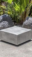 Gray Stone Cube Sculpture in a Garden Setting photo