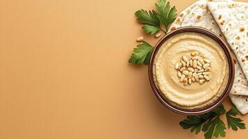 Delicious Homemade Hummus in a Rustic Bowl, Topped with Pine Nuts and Fresh Parsley, Displayed on a Neutral Beige Background with Pita Bread This vibrant food photograph captures the creamy texture photo
