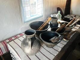 Traditional Ceramic and Wooden Utensils on a Textile Tablecloth in a Rustic Interior photo