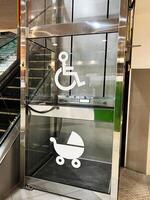 Accessible elevator with wheelchair and baby stroller symbols at a public location photo