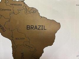 Gold map highlighting Brazil and surrounding South American countries on decorative background photo