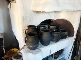 Rustic clay pots on a traditional white oven in a cozy rural setting photo