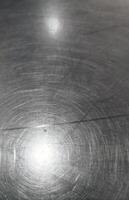close up view of scratched metal surface, showcasing its texture and reflections photo