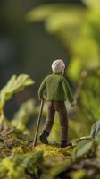 miniature clay figure of elderly man with white hair walking through greenery, showcasing sense of adventure and exploration photo