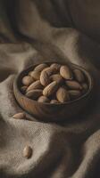 wooden bowl filled with almonds on textured fabric background, creating warm and inviting atmosphere photo