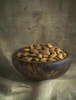 wooden bowl filled with almonds on burlap background creates rustic and inviting atmosphere photo