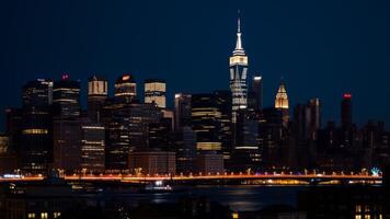 Night View of Illuminated Manhattan Skyline with Skyscrapers and Bridge photo